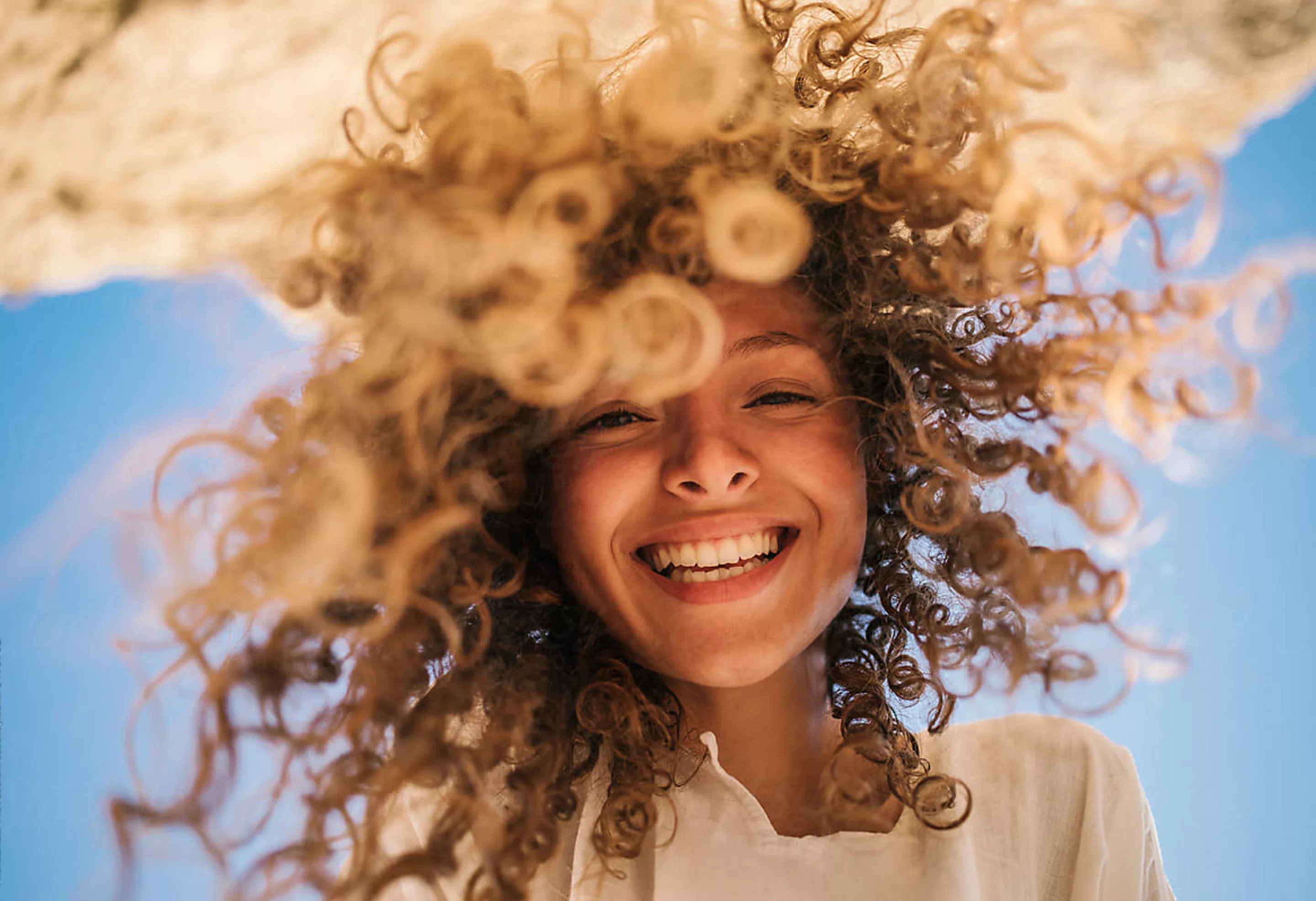 Frau mit locken lacht in kamera